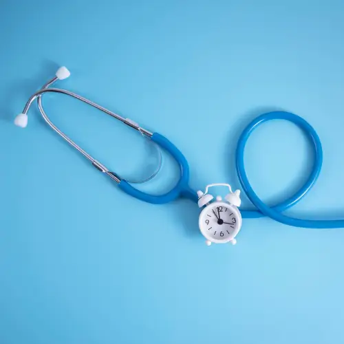 Stethoscope shaped like a clock on blue background representing medical compliance and timely documentation.